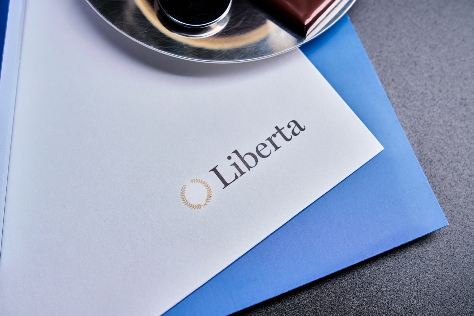 Liberta printed identity on a blue surface.