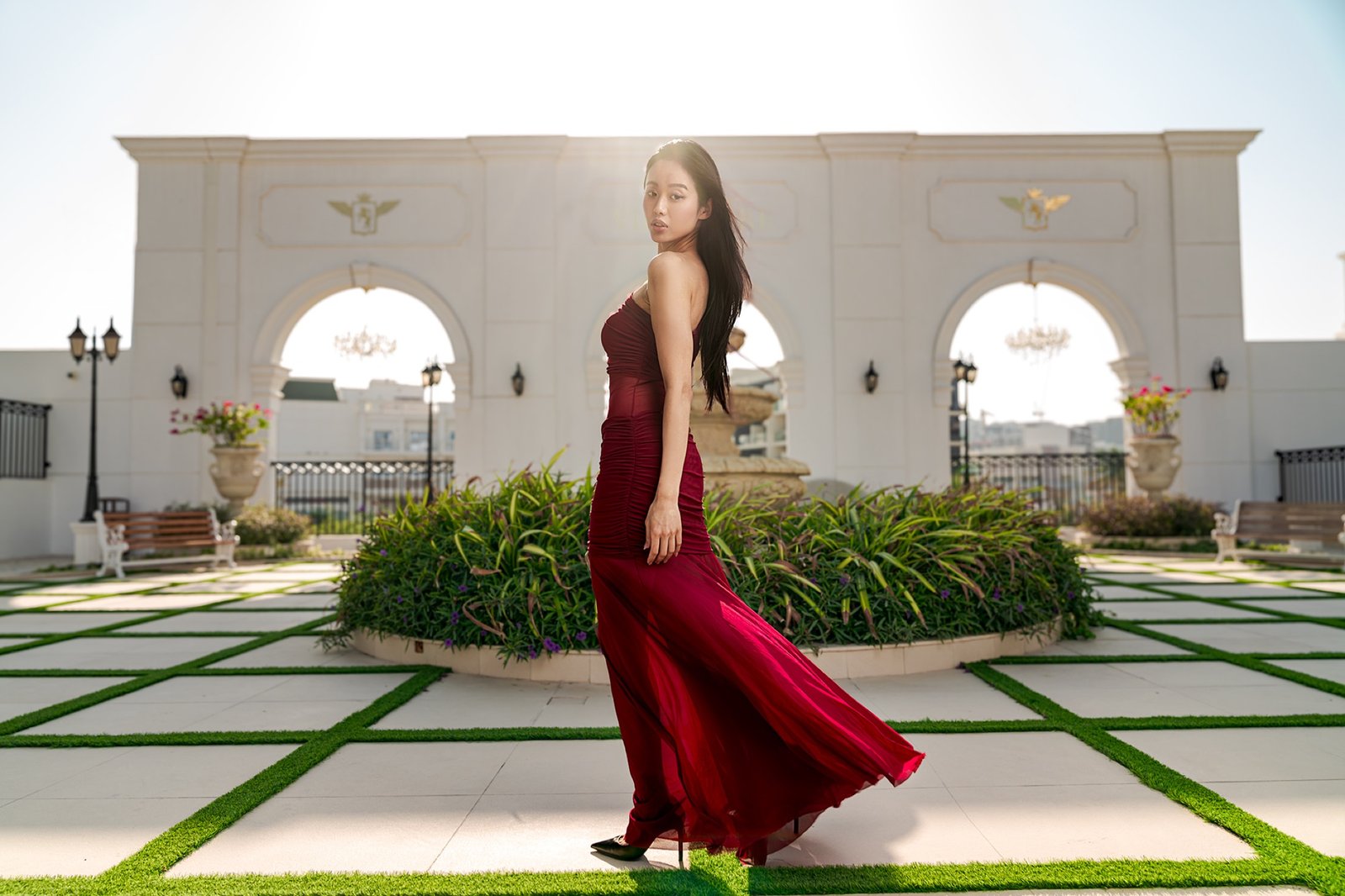 A burgundy gown and pale arches, Gemini Agency.