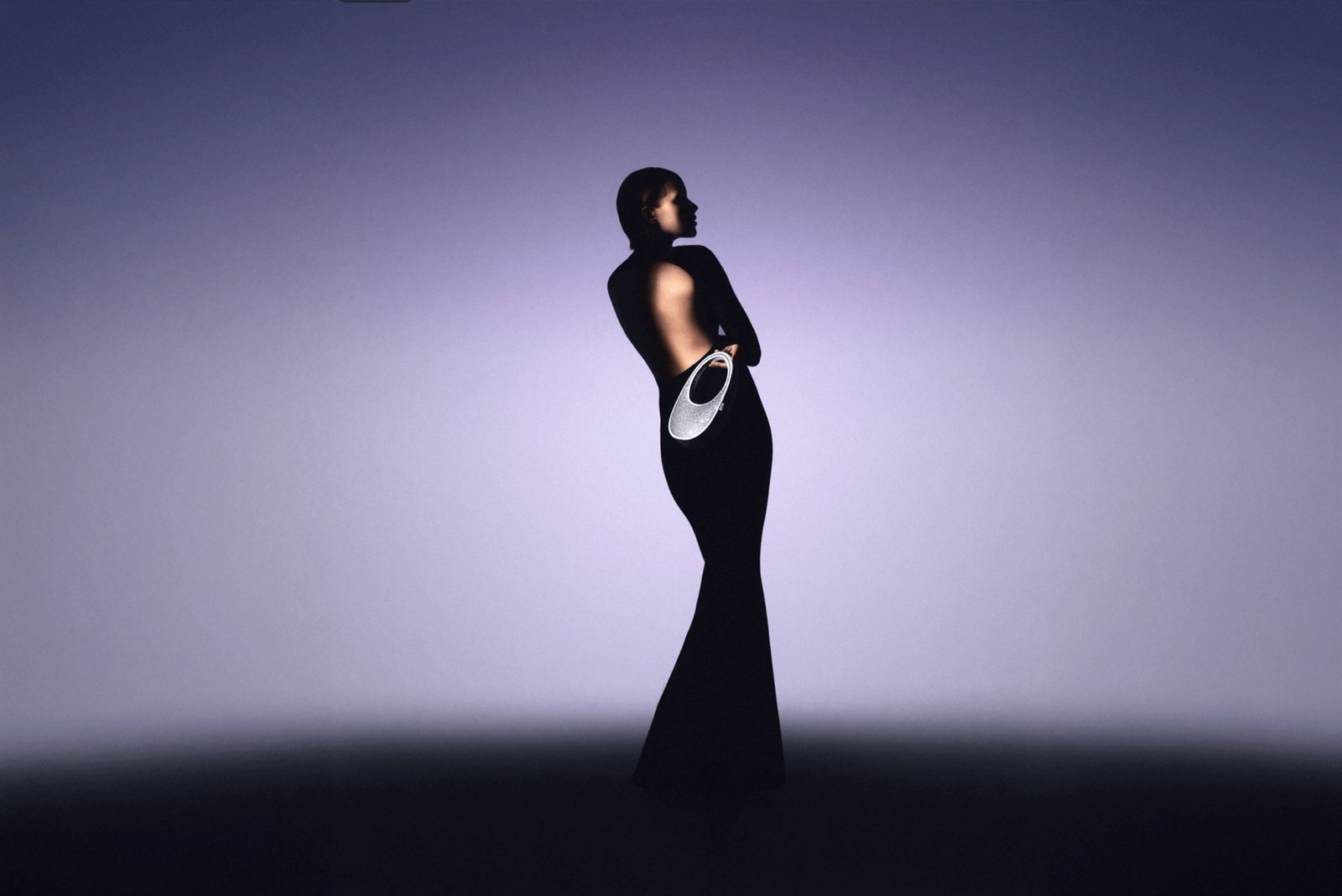 Florencia in a black dress against a violet backdrop, an editorial collaboration.