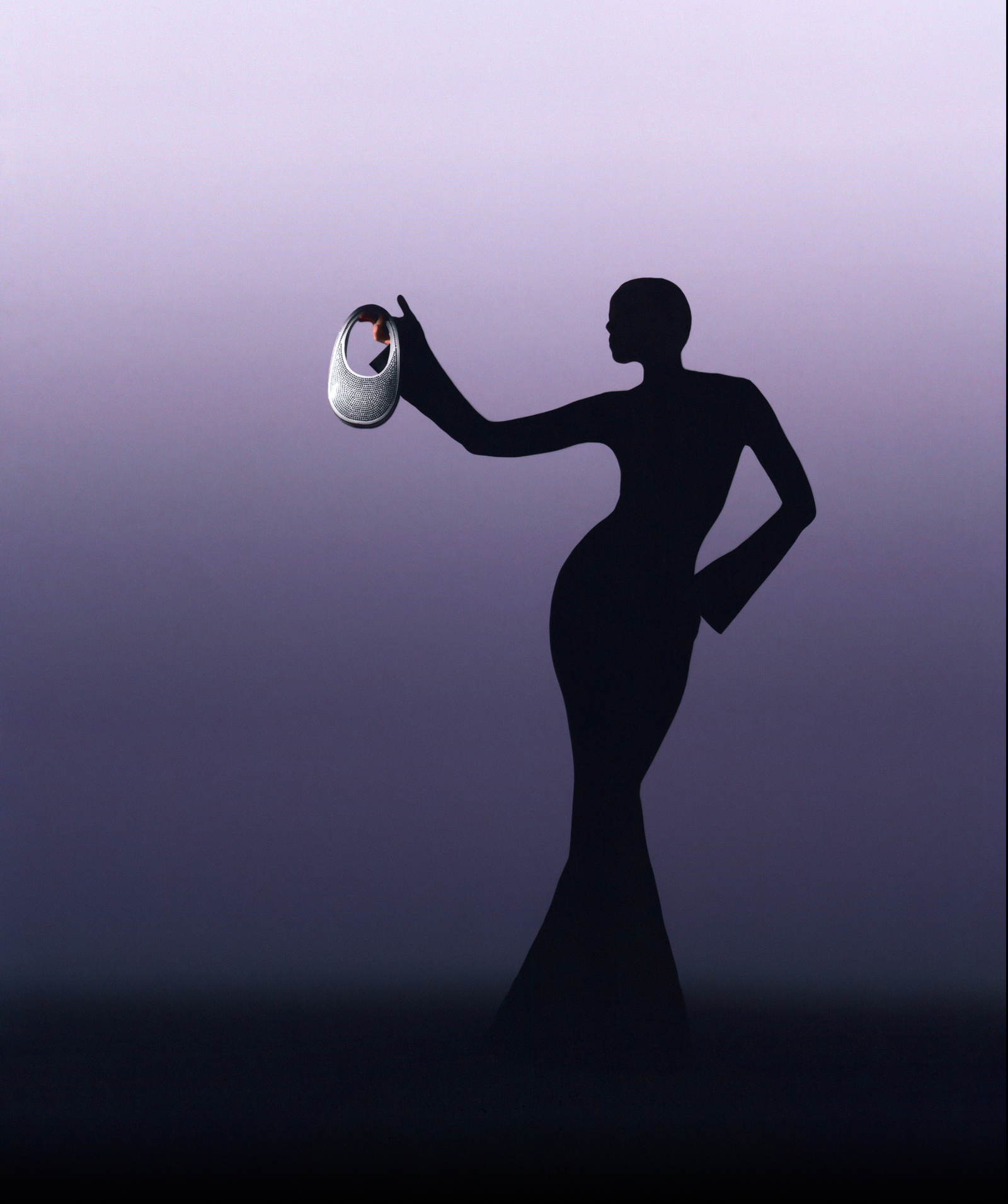 Silhouette of a woman holding a designer handbag